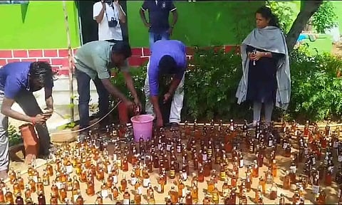 பறிமுதல் செய்யப்பட்ட மதுபாட்டில்களை போலீசார் அழித்தக் காட்சி.