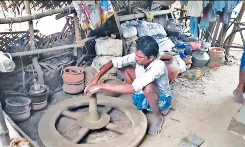 அகல் விளக்கு தயாரிக்கும் பணியில் ஈடுபட்டுள்ள தொழிலாளர்.