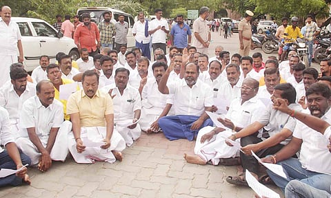 ஆர்.பி.உதயகுமார் தலைமையில் அ.தி.மு.க.வினர் தரையில் அமர்ந்து தர்ணா போராட்டத்தில் ஈடுபட்ட காட்சி.