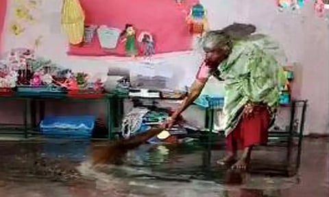 மழைநீரை அகற்றும் பணியில் ஈடுபடும் துப்புரவு ஊழியரை படத்தில் காணலாம்.