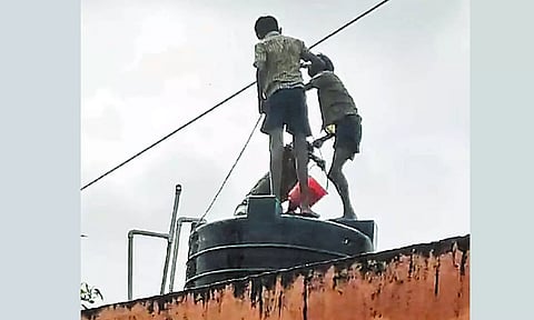 மாநகராட்சி பள்ளியின் மாடியில் உள்ள குடிநீர் தொட்டியை சுத்தம் செய்த மாணவர்கள்