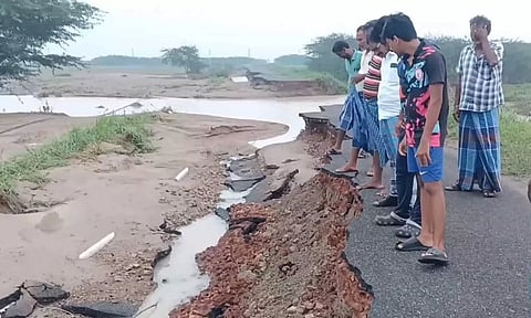 காட்டாற்று வெள்ளத்தில் அடித்து செல்லப்பட்ட சாலையை படத்தில் காணலாம்.