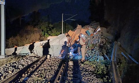 தண்டவாளத்தில் லாரி நொறுங்கி கிடப்பதையும், சம்பவ இடத்தில் போலீசார் மீட்பு பணியில் ஈடுபட்டதையும் காணலாம்.