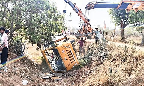 12 அடி பள்ளத்தில் கவிழ்ந்த தனியார் பள்ளி பஸ்