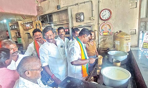பா.ஜனதா வேட்பாளர் பாலகணபதி டீக்கடையில் டீ போட்டு கொடுத்து ஓட்டு வேட்டை