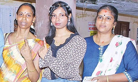 சிங்கப்பூரிலிருந்து வந்து முதல் வாக்கை பதிவு செய்த இளம் பெண் (நடுவில் நிற்பவர்).