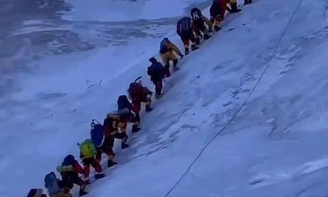 எவரெஸ்ட் சிகரத்தில் கூட்டமாக மலையேறும் பயணிகள்