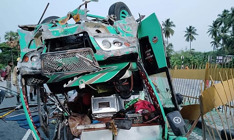 தலைக்குப்புற கவிழ்ந்து விபத்துக்குள்ளாகி கிடக்கும் மினி பஸ்சை காணலாம்