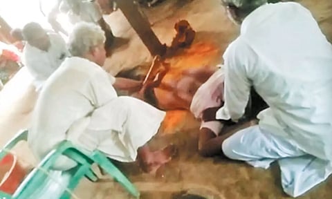வாலிபரின் வயிற்றில் பூசாரி ஜக்கப்பா கோடரியால் வெட்டுவதை காணலாம்.