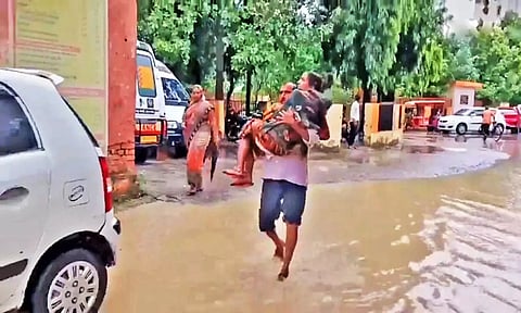 உத்தரபிரதேசத்தில் வெள்ளம்: சாலையில் மனைவியை தூக்கிச் சென்ற கணவர்