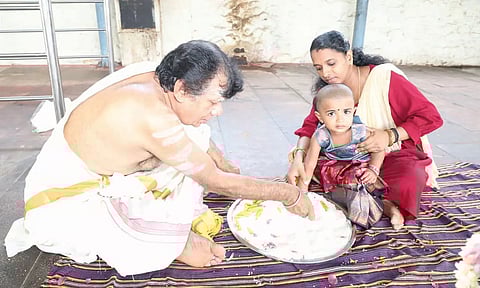 நாகர்கோவில் நாகராஜா கோவிலில் நடந்த வித்யாரம்பம் நிகழ்ச்சியில் அரிசியில் ‘அ’ எழுதும் குழந்தை.