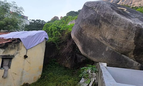  கிருஷ்ணகிரி மலையில் இருந்து உருண்டு வந்து விழுந்த ராட்சத பாறையை காணலாம்