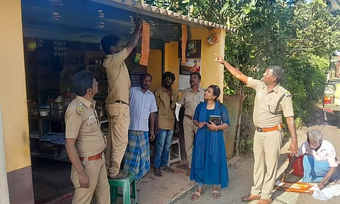 வீட்டின் வாசல் முன்பு மிளகாய் பொடி கரைசலில் ஊற வைத்த துணிகளை வனத்துறையினர் கட்டுவதை படத்தில் காணலாம்.