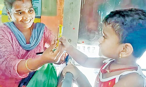 பஸ்சில் தனியாக அமர்ந்திருந்த குழந்தையிடம் சாக்லெட் கொடுத்து கொஞ்சி மகிழ்ந்த பயணிகள்.