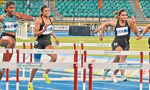 100 மீட்டர் தடை ஓட்டத்தில் தமிழகத்தின் நந்தினி (இடது) இலக்கை நோக்கி முன்னேறும் காட்சி.