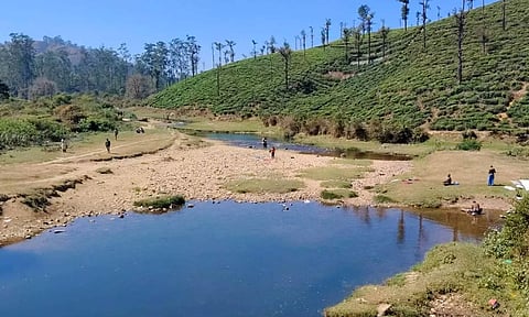 நீர்மட்டம் குறைந்தும், சுற்றுலா பயணிகள் இன்றி வெறிச்சோடி காணப்படும் கூழாங்கல் ஆறு.