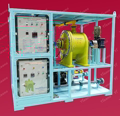 A detailed photograph of the skid-mounted Tiaano ElSr – SC / M – 500, a complete, self-contained electrolytic scale removal unit. The unit is built within a light blue industrial frame on a solid base. The left side features two stacked control panels with multiple English-labeled meters (e.g., conductivity, DC volts/amps), switches, and indicator lights.