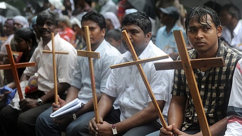 Indian Dalit Christians sit in the rain during a protest for equal rights.