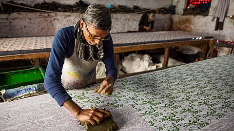 A block printing patterns on fabric.