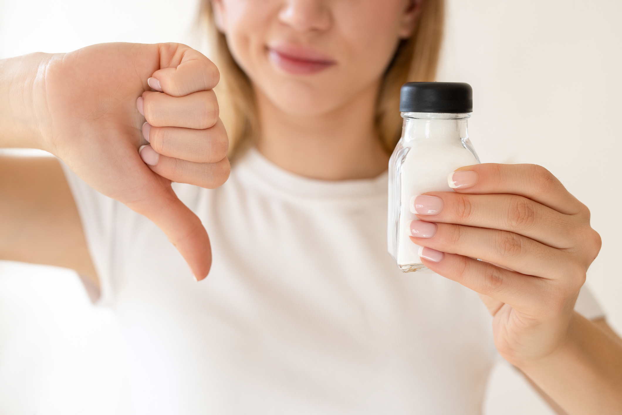 Reducing salt intake helps lower sodium levels, which play a harmful role in hypertension.