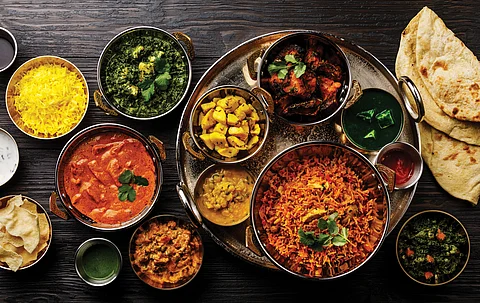 Indian food Curry butter chicken, Palak Paneer, Chiken Tikka, Biryani, Vegetable Curry, Papad, Dal, Palak Sabji, Jira Alu, Rice with Saffron on dark background