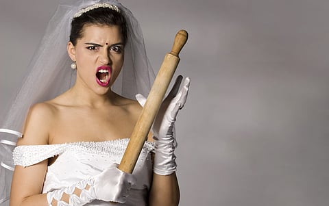 Killer bride photo series. Bridezilla with wooden rolling pin. Studio shot