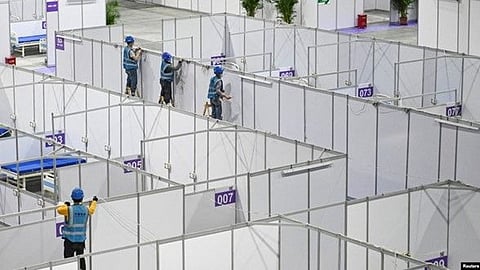 Workers set up equipment inside Pazhou International Convention Exhibition Center to convert it into a makeshift hospital, in Guangzhou, Guangdong province, China, April 10, 2022 (VOA)