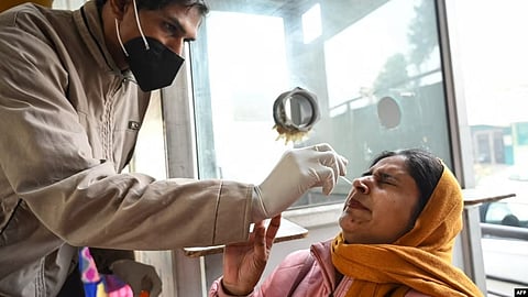 A health worker collects a nasal swab sample from a woman to test for COVID-19 at a hospital in Amritsar on Jan. 5, 2023