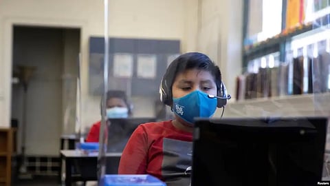 Chrystopher Camey Lopez uses a computer from a socially-distanced desk during an in-person hybrid learning day at the Mount Vernon Community School in Alexandria, Virginia, March 2, 2021(VOA)