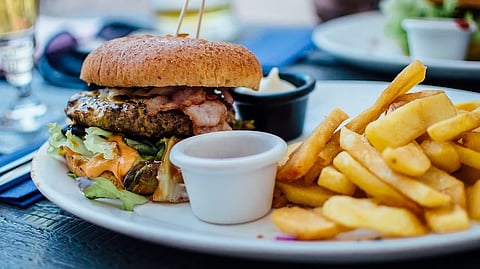 A plate featuring a juicy hamburger with lettuce and tomato, accompanied by a side of golden, crispy fries.