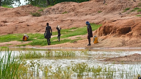 Children in the town of Terekeka, South Sudan, draw water, Oct. 4, 2017, from a stagnant pond that was once infected with Guinea worm when the town was endemic