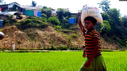 A Rohingya boy carries food rations for his family from a World Food Program-run shop in a refugee camp, Cox’s Bazar, Bangladesh, June 12, 2022.