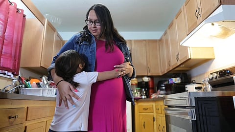 Cloie Davila
stands
with her daughter, Amelia,
at home in Clayton, New Mexico.
Davila,
who is
expecting
her
third child, may be one of the last
to benefit from
a federally
funded
rural
maternity
program.
(Joe Garcia III for KFF Health News)