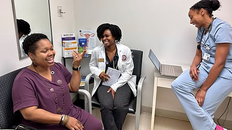 YaSheka Shaw (left) celebrates losing weight
during a
checkup
with medical student Kaniya Pierre Louis (center) and
physician
Zita Magloire.