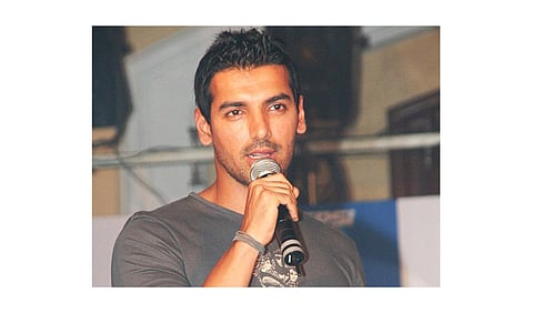 An image of an Indian actor John Abraham holding mike.