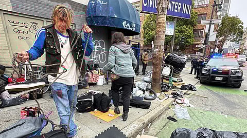 Andrew Douglass, who is homeless and lives on the streets of San Francisco, gathers his belongings as the San Francisco Police Department orders him to move off the sidewalk, where he has slept for months, or get arrested.