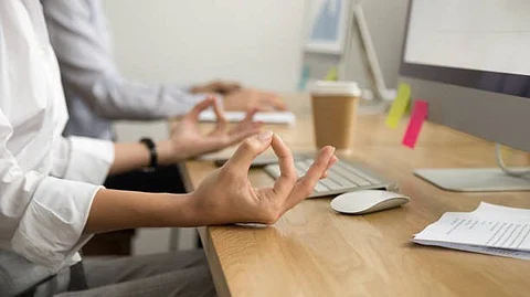 A person sitting in front of a practicing yoga or meditation.