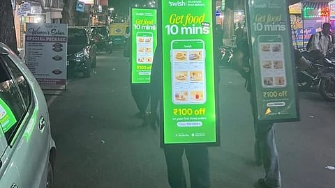 Images of men walking around with billboards advertising for the app went viral. (Image source: @roshanonline/X)