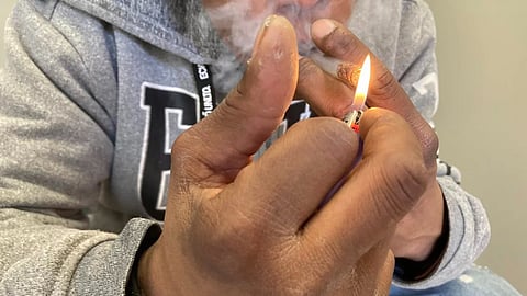 A middle-aged man smokes crack cocaine in Rhode Island. The state had the country’s fourth-highest rate of overdose deaths involving cocaine in 2022. (Lynn Arditi/The Public’s Radio)
