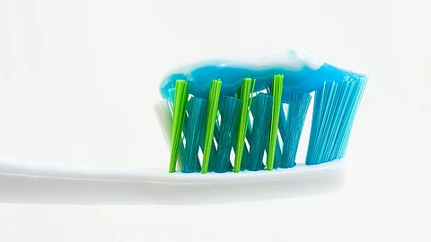 Tooth brush with toothpaste on it.
