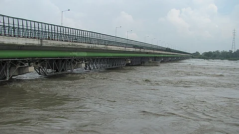 Picture showing a unclean Yamuna with brownish river water.