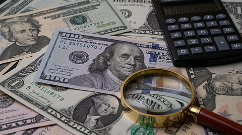 Banknotes of different denominations, a magnifying glass, and a calculator