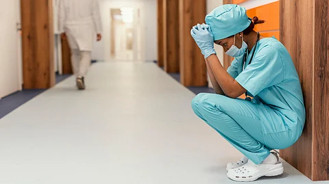 Full shot tired health worker sitting