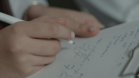 Person Writing on White Paper