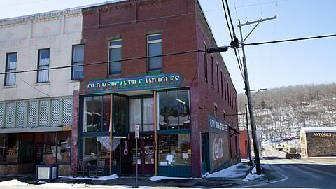 Street has a two-story building showing an antique shop.