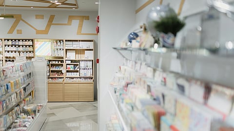 Inside of a pharmacy showing several stacks and rows of medicines arranged.