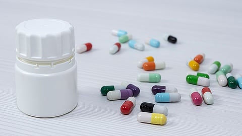 A bottle of pills lies on the ground.