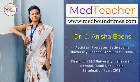 A photo of Dr. Anisha in a saree leaning against a wall.