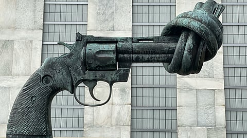 A sculpture of a gun with its barrel knotted.