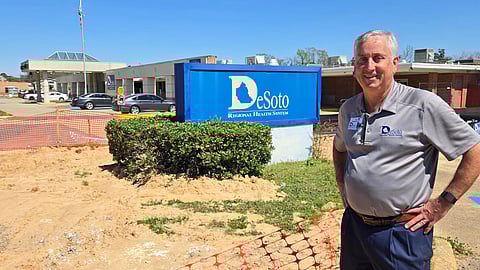 A picture of Todd Eppler standing in front of the rural hospital under renovation.